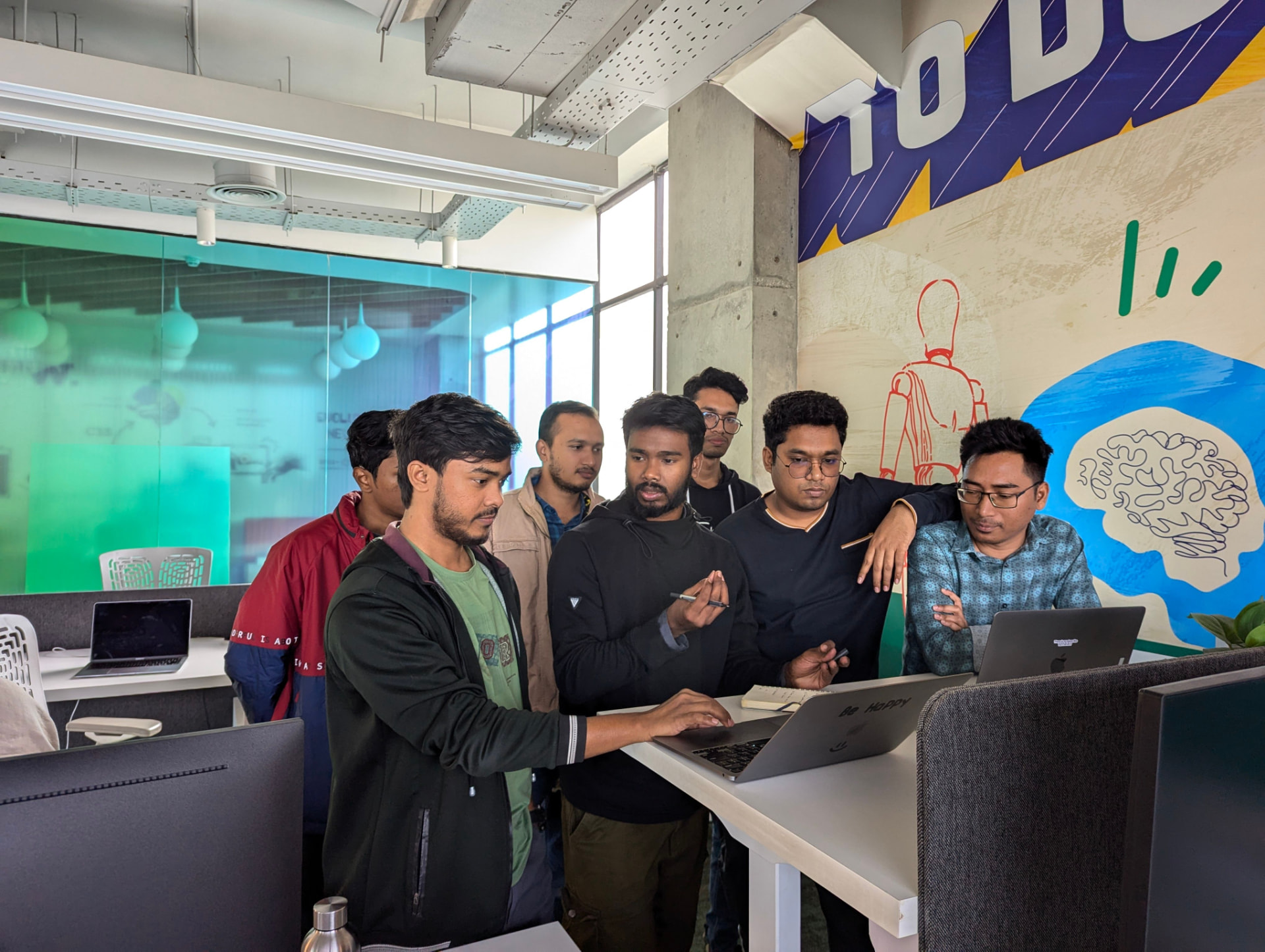 A startup team gathered around a laptop in a creative office